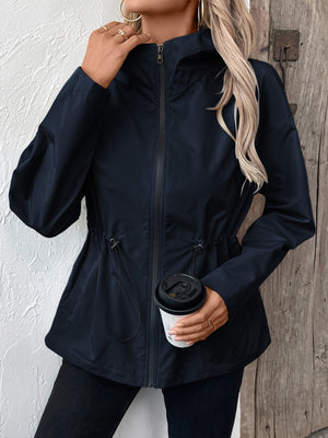 Navy utility jacket with cinched waistline, zipper, and hood.