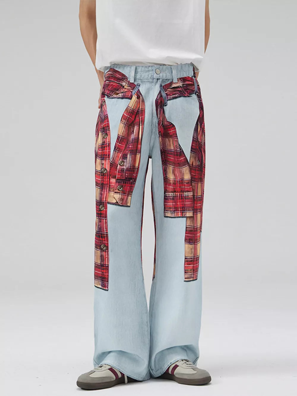 Men's light wash wide-leg jeans with red plaid patchwork details and button accents.