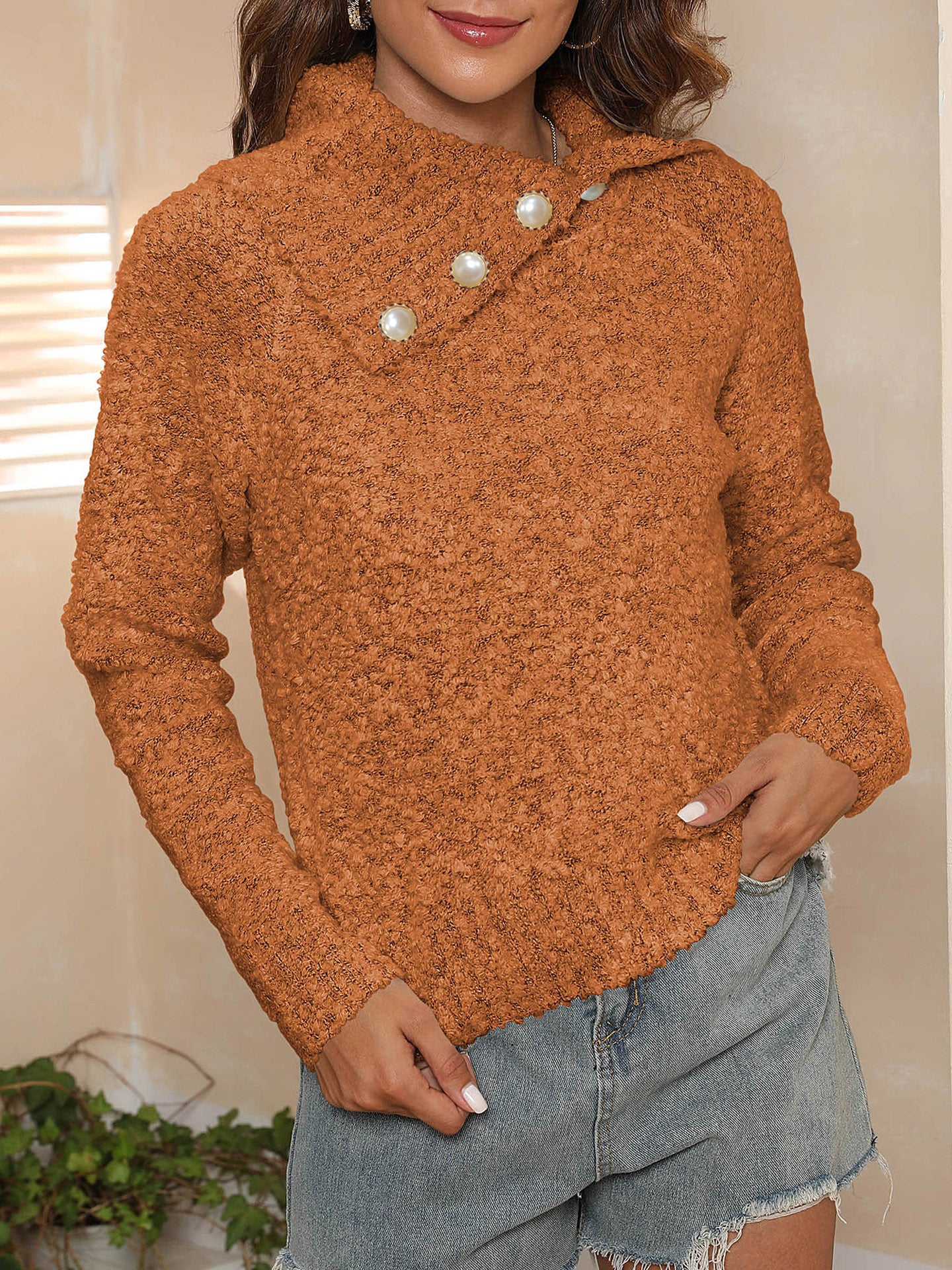 Tangerine textured knit sweater with pearl button asymmetric collar and long sleeves.