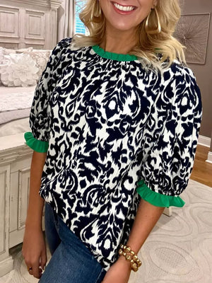 Damask print maternity blouse with ruffled green neckline and cuffs.