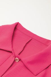 Oversized shirt romper in hot pink with a buttoned collar detail.