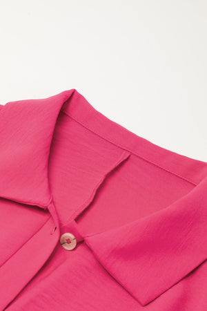 Oversized shirt romper in hot pink with a buttoned collar detail.