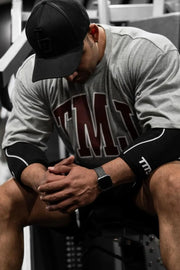 Gray oversized graphic tee with athletic appeal and bold maroon lettering.