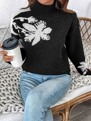 Black mock neck knit sweater with white floral embellishments and subtle sparkle detail.