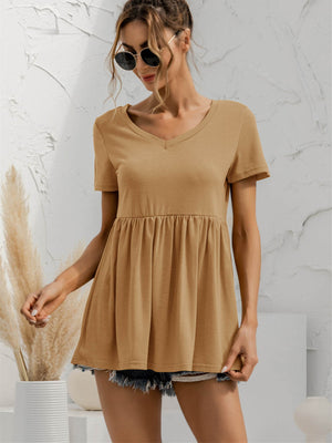Khaki v-neck tee with gathered waistline and short sleeves, styled with denim shorts.