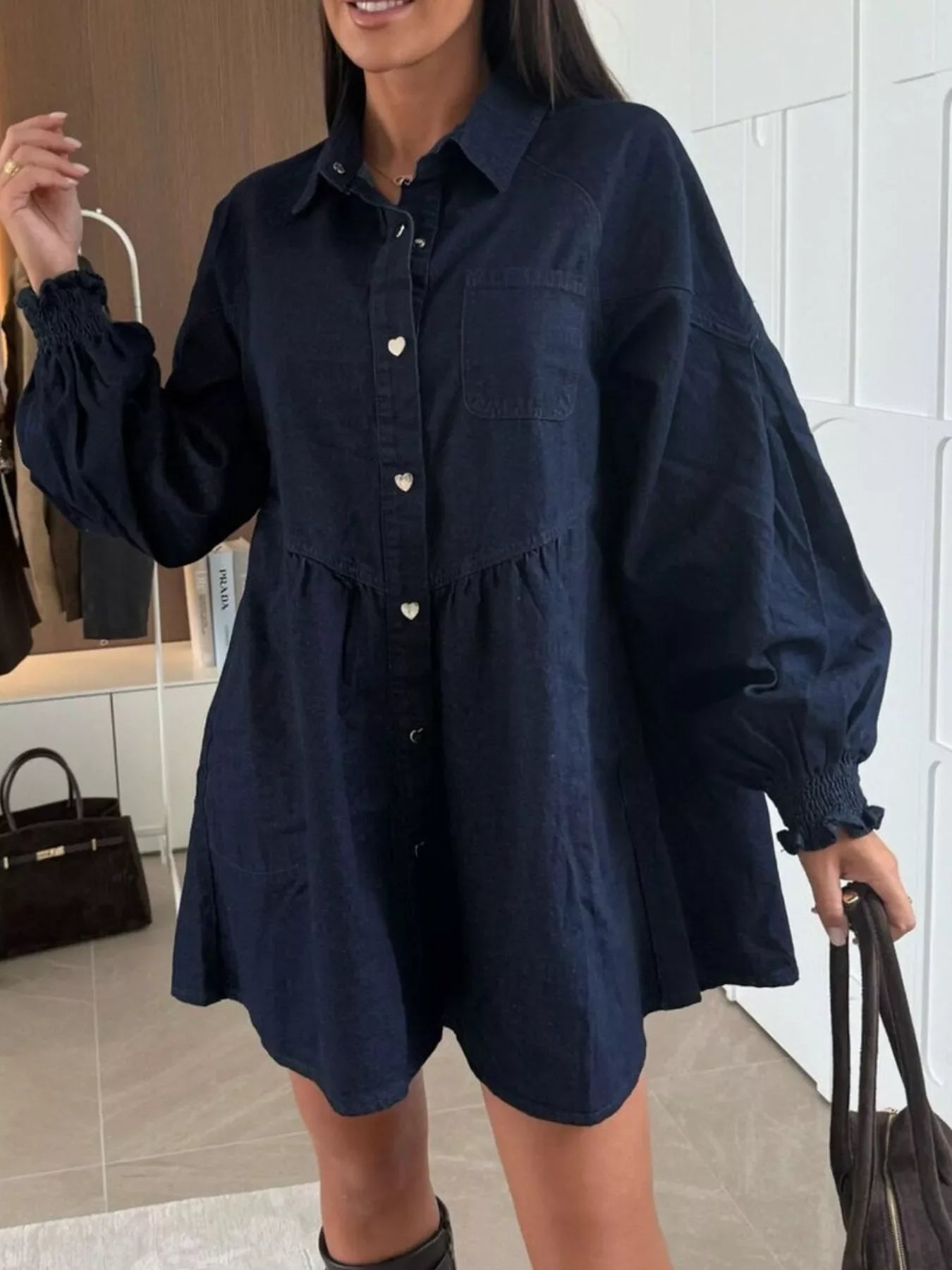 Dark blue denim mini dress with heart buttons, pockets, and smocked cuffs.