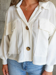 Textured white boxy utility shirt jacket with button front and chest pockets.
