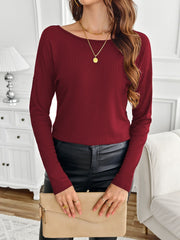 Burgundy ribbed knit long sleeve top with a boat neckline, styled with black pants and a clutch.
