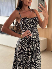 Tie-shoulder midi dress with zebra print, adjustable straps, and button front.