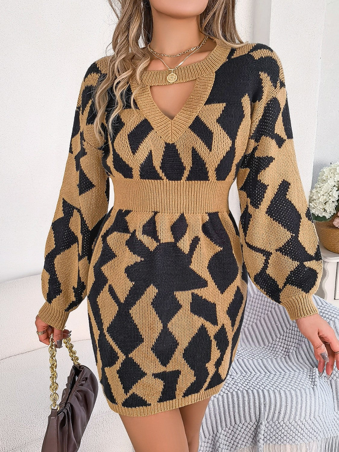 Geometric cutout knit mini dress in Khaki with black pattern, V-neck, long sleeves, and cinched waist.