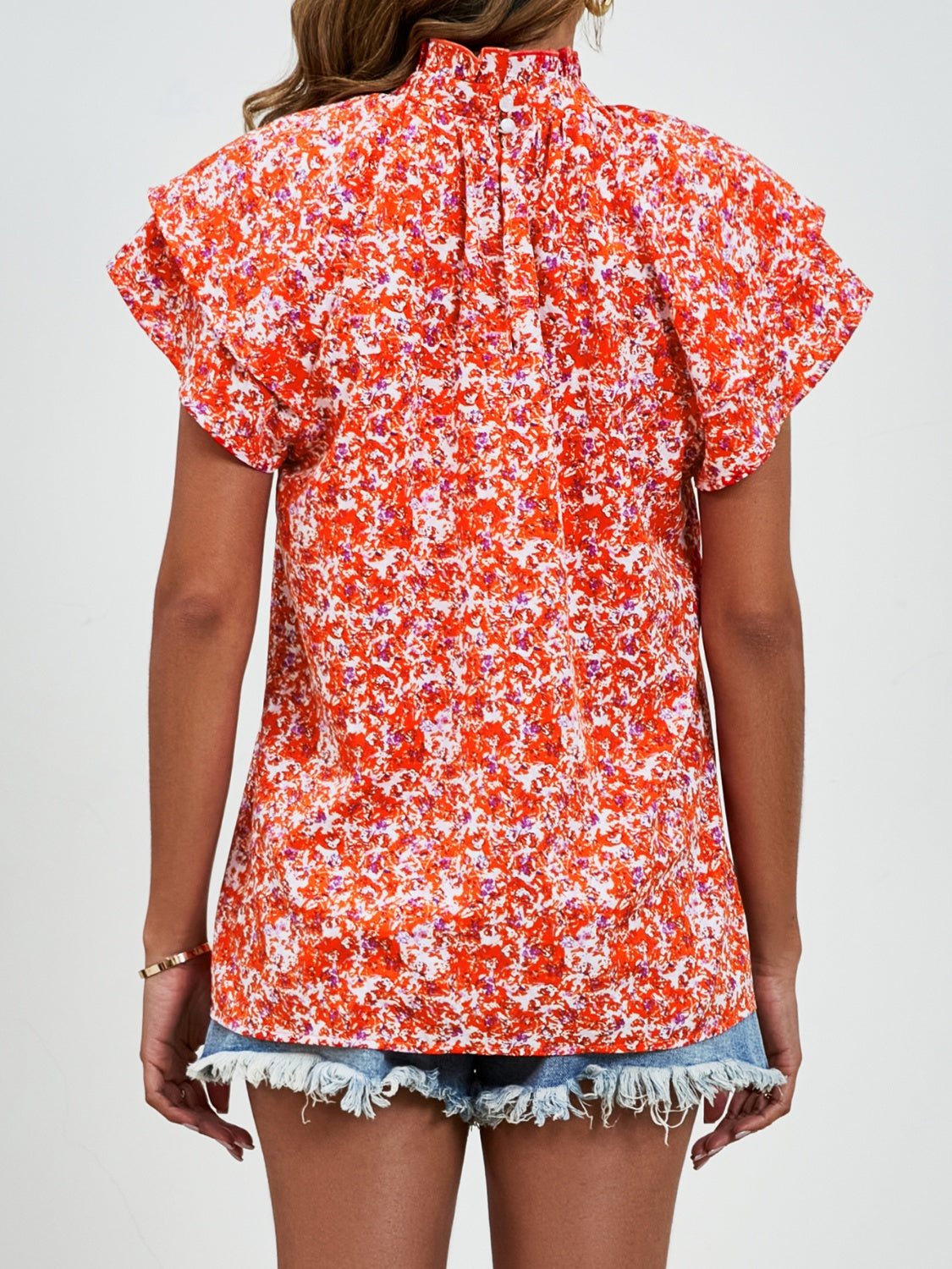 Orange floral ruffled neck flutter sleeve blouse with button back detail.