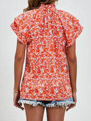 Orange floral ruffled neck flutter sleeve blouse with button back detail.