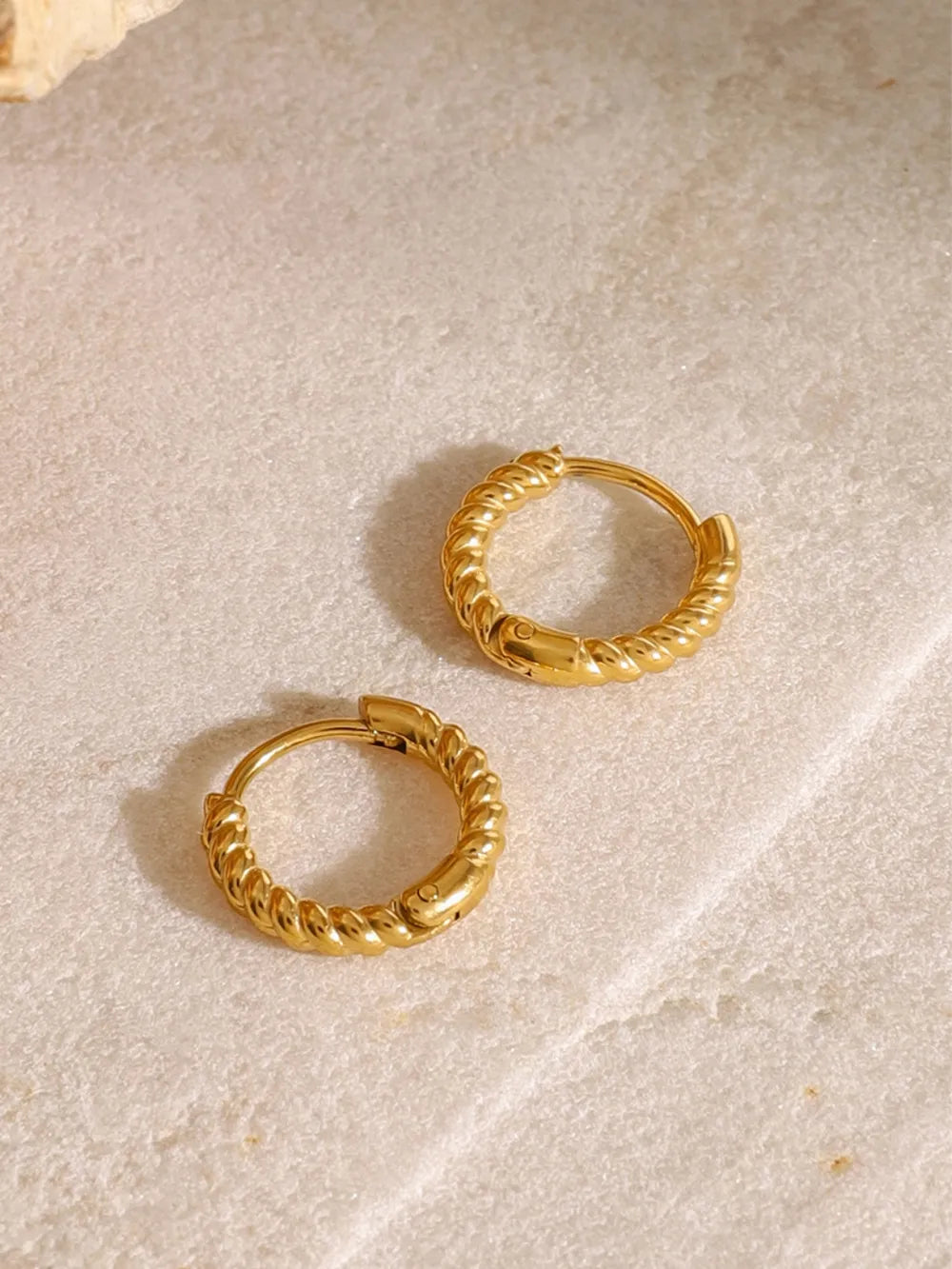 Gold twisted mini hoop earrings with a textured rope design.