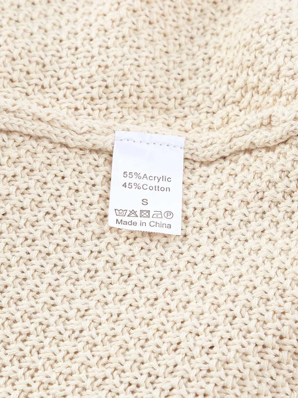 Beige knit sweater with care tag showing 55% Acrylic, 45% Cotton.