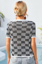 Checkerboard knit crewneck top in black and white with short sleeves.
