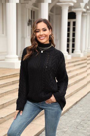 Black cable-knit turtleneck sweater with voluminous silhouette and acrylic material.