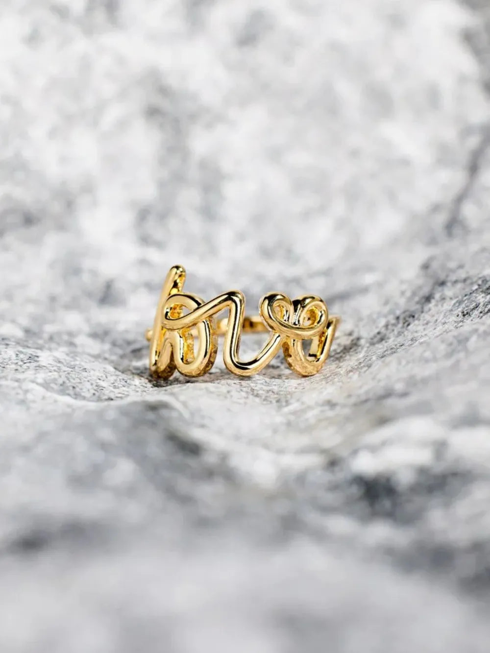 Gold scripted love ring with delicate cursive lettering