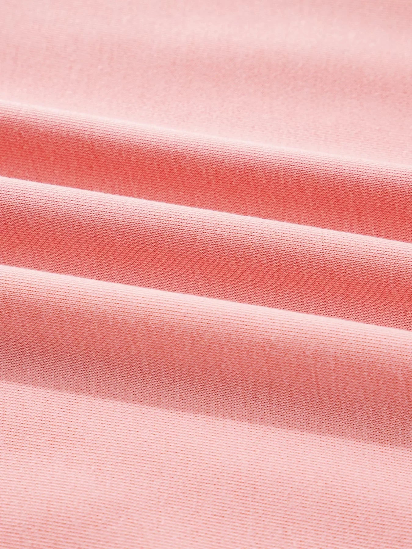 Oversized dusty pink sweatshirt with contrast stitching detail, showing textured fabric.