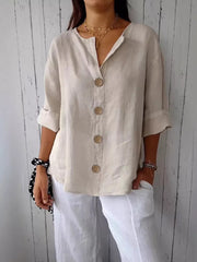 Beige button-down shirt with relaxed fit and three large buttons, 3/4 sleeves.