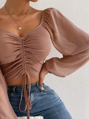 Camel ruched bodice puff sleeve crop top with drawstring detail.