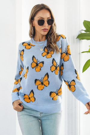 Light blue acrylic knit crewneck pullover sweater with allover orange butterfly motif.