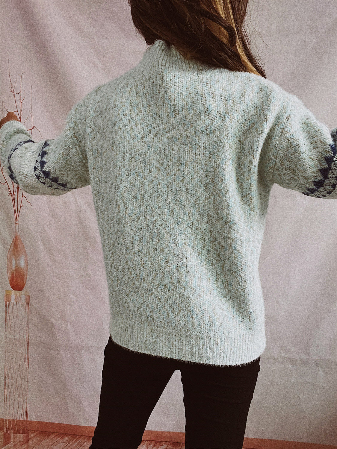 Geometric knit mockneck pullover in Cloudy Blue acrylic with a flecked texture and navy geometric sleeve detail.