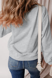 Gray crewneck sweatshirt with cartoon ghost graphic, casual autumn style.