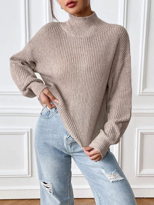 Relaxed fit beige ribbed knit turtleneck sweater with long sleeves.