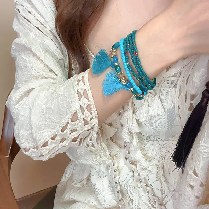 Beaded stacked bracelet set in royal blue with turquoise tassels and bronze accents.