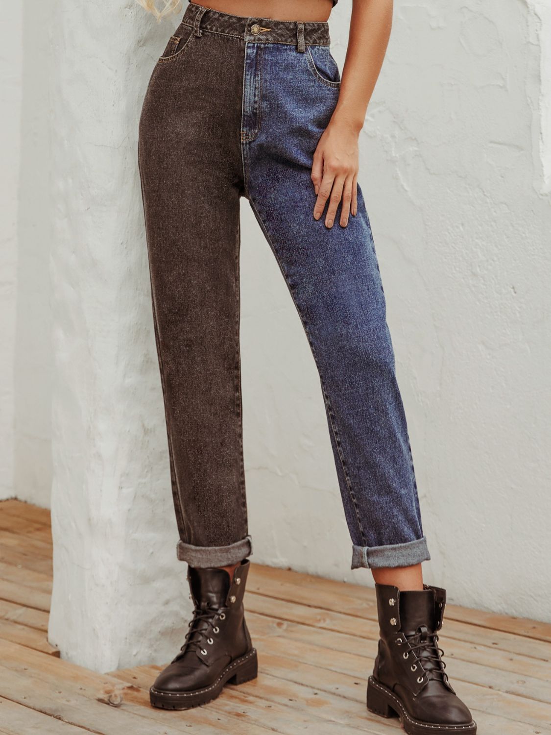 Split-tone straight leg jeans in medium wash denim and charcoal with cuffed hems.