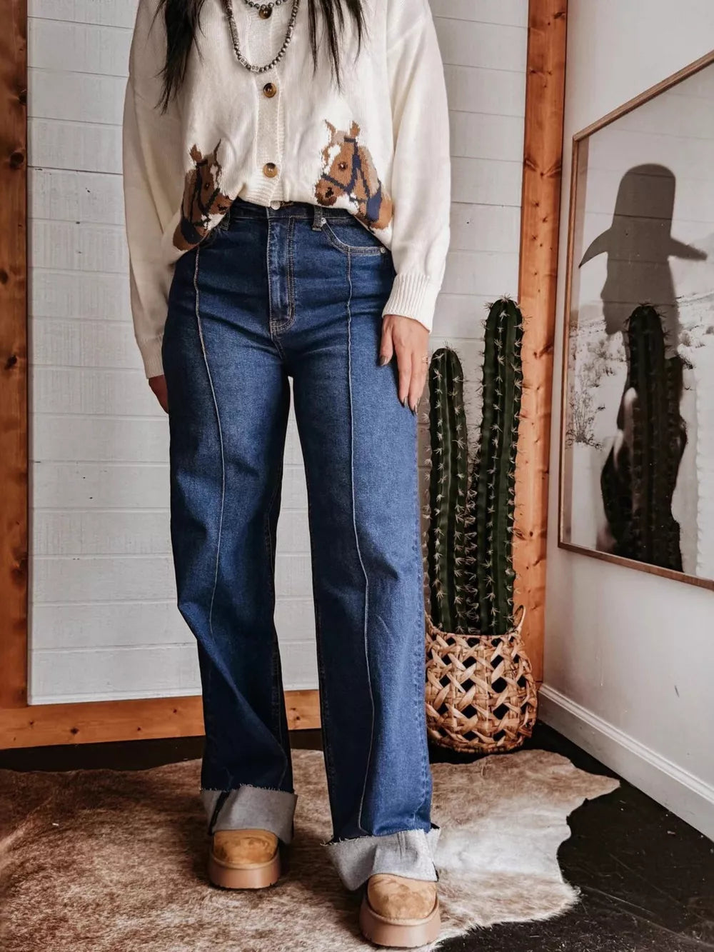 Dark blue denim wide-leg jeans with buttoned pockets and a raw hem