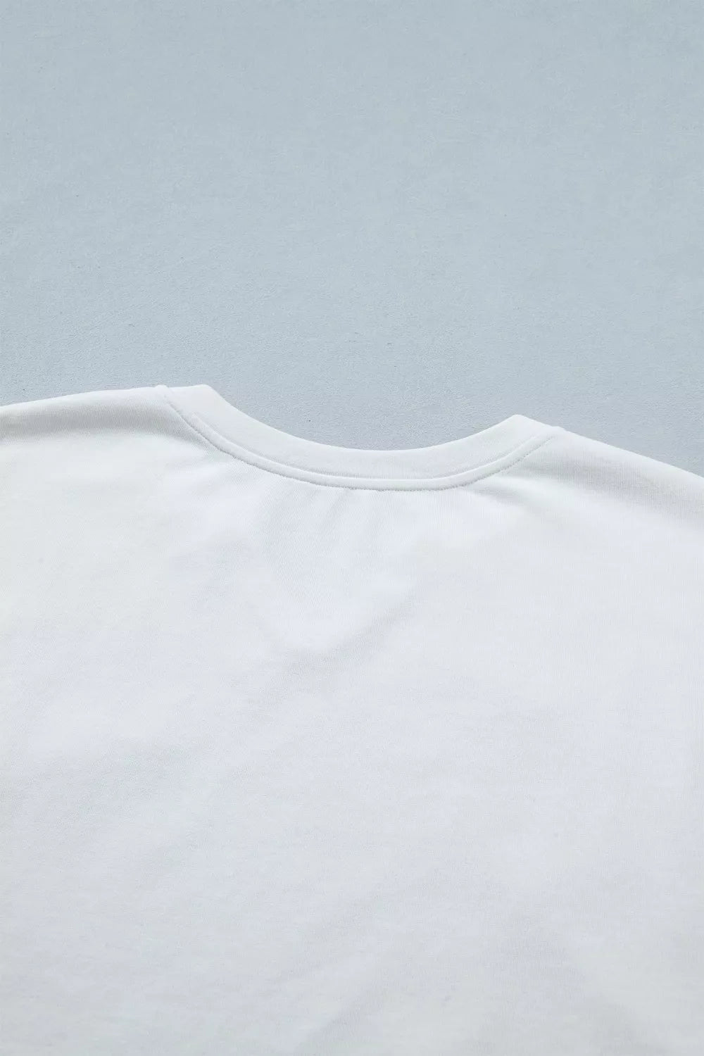White cotton maternity tee with notched neckline and star applique detail.
