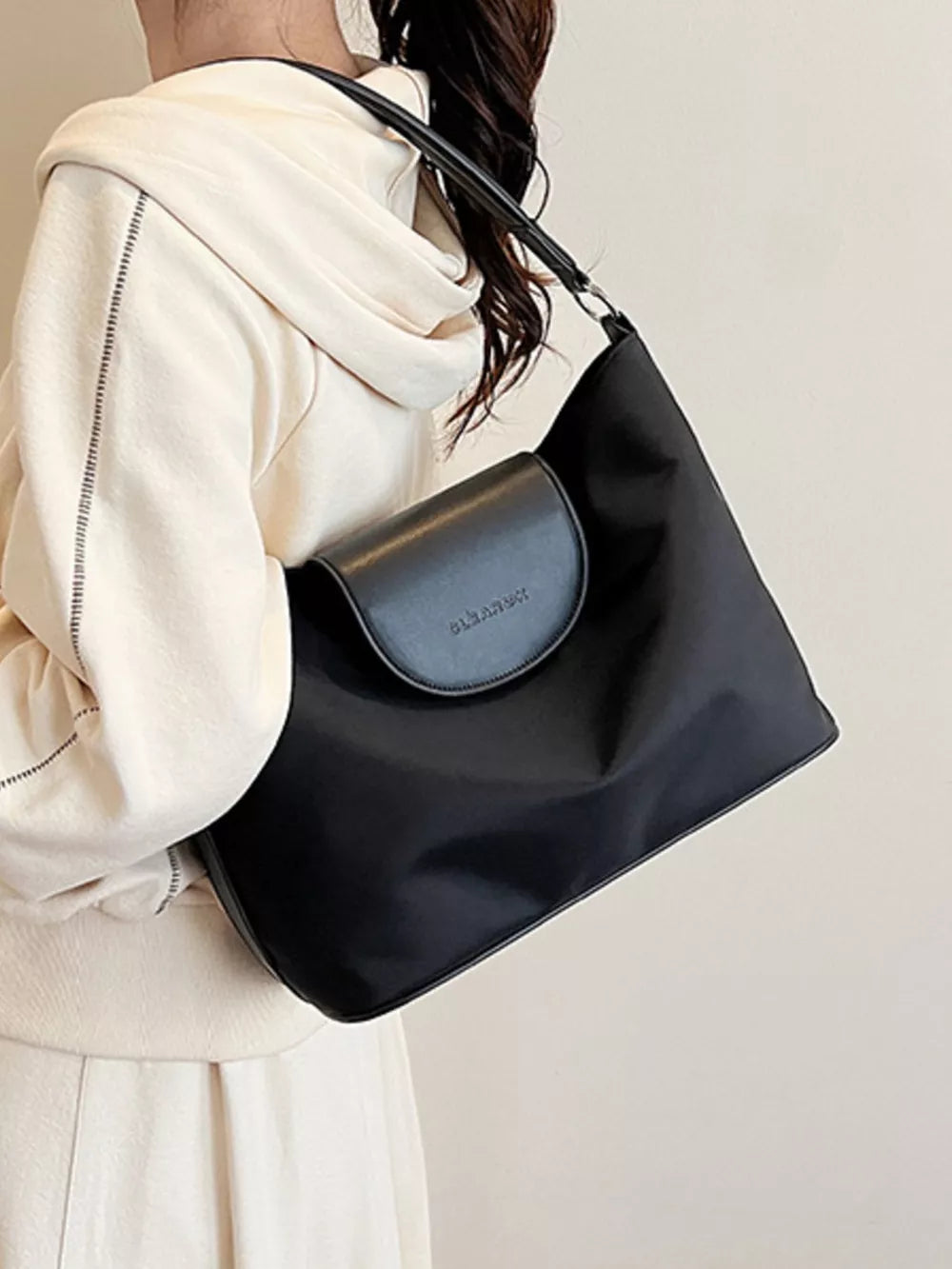 Chic black canvas hobo crossbody bag with flap closure and subtle logo detail.