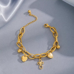 Gold charm bracelet with heart and cross pendants and bead accents