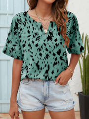 Turquoise dalmatian print blouse with notch neck and short sleeves.