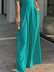 Teal romper with cinched waist, deep v-neck, and puff sleeves.