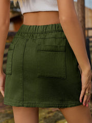 Dark green denim mini skirt with elastic waist and buttoned pockets.