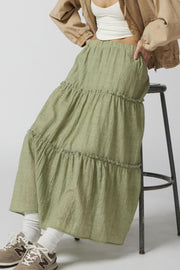 Tiered cotton maxi skirt in matcha green with ruffled tiers and an elastic waist.