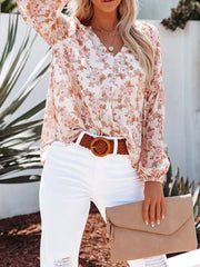 Floral print V-neck long sleeve maternity shirt in white with pink and green blooms.