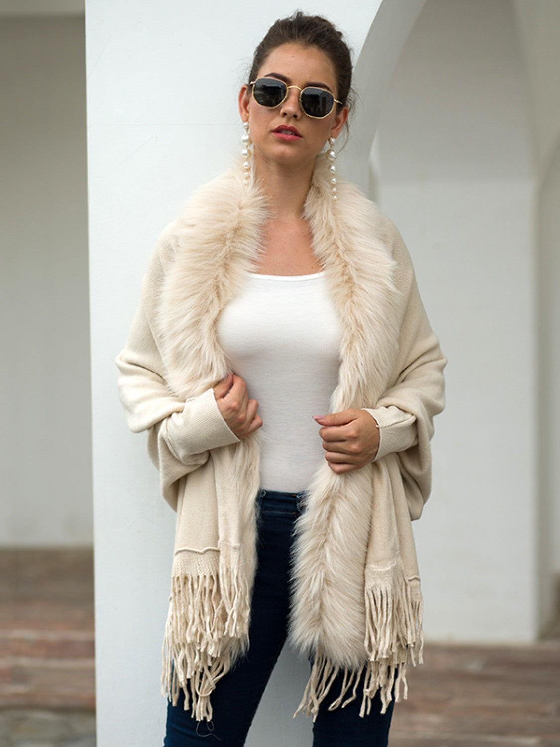 Ivory faux fur trimmed fringe cape with a boho casual style.