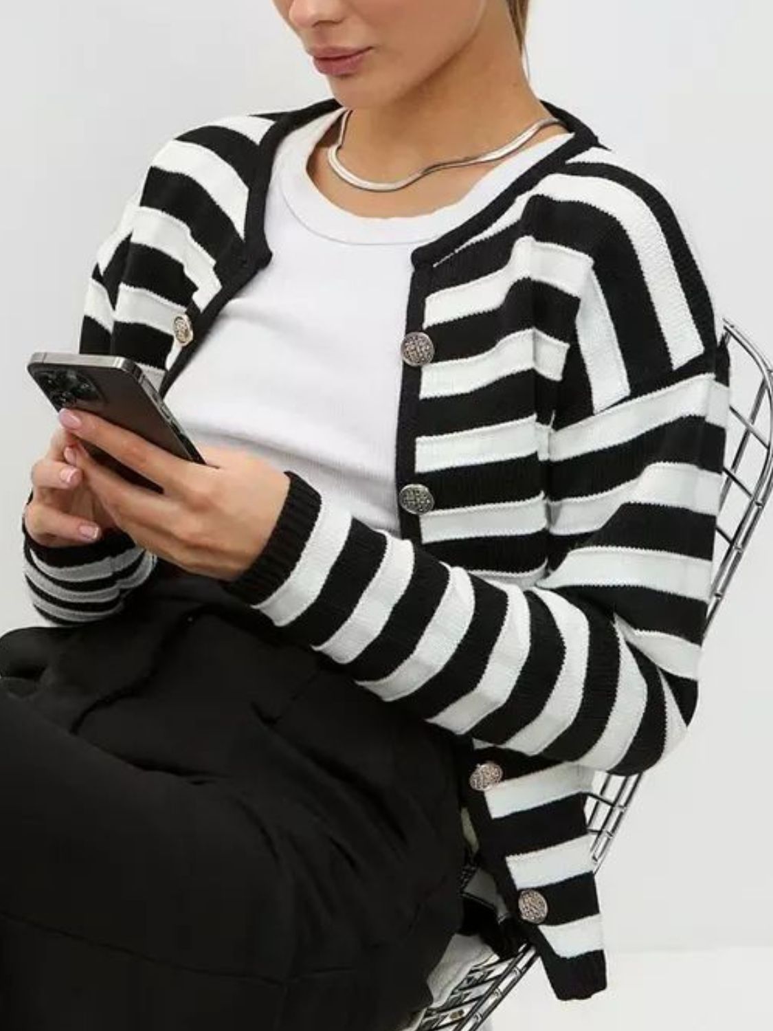 Black and white striped button-up knit cardigan with silver buttons.