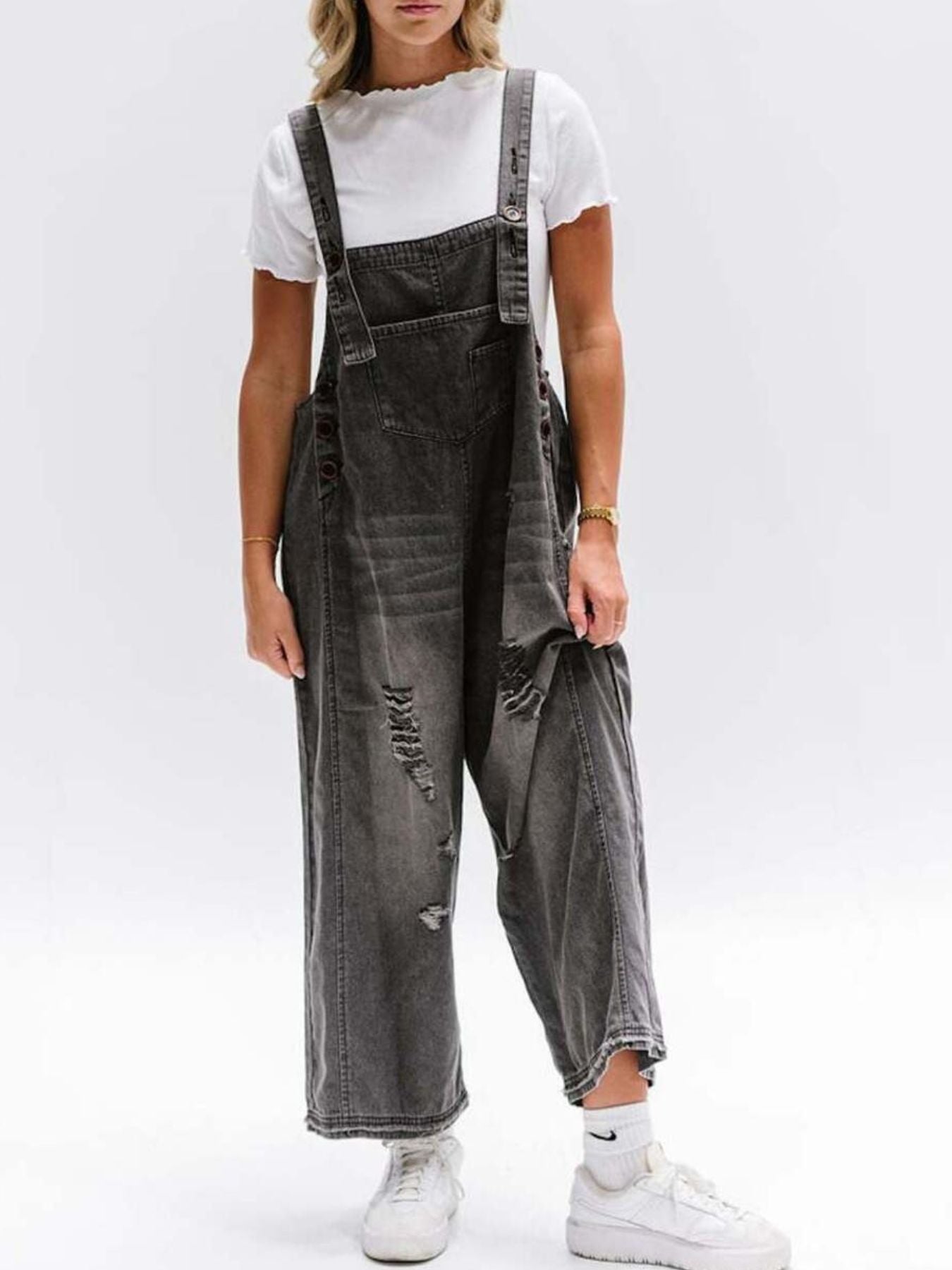 Ripped relaxed fit denim overalls in dark blue with distressed details and adjustable straps.