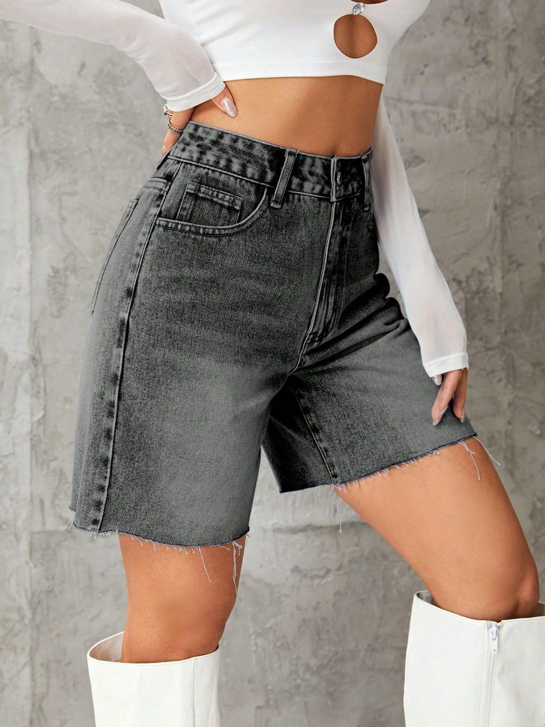 High-waisted dark gray denim Bermuda shorts with frayed hem and button closure.