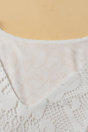 White lace peplum blouse with scalloped hem and V-neck detail.