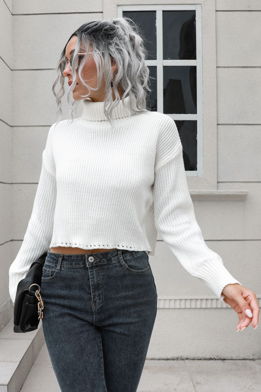 White ribbed turtleneck sweater with scalloped hem detail and long sleeves.