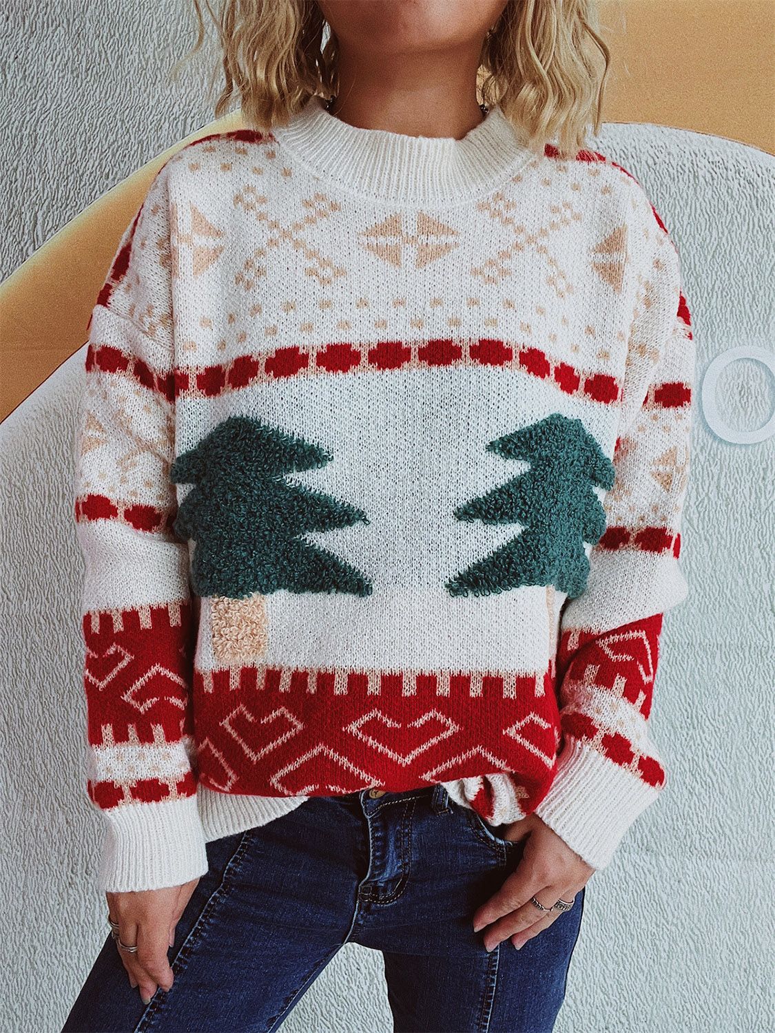Beige knit sweater with festive appliqué trees and geometric patterns.