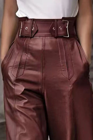 Burgundy wide-leg leather pants with a detailed buckle belt and pleated front.