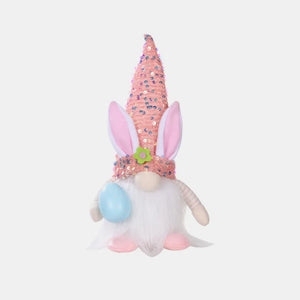 Easter bunny gnome with pink sequin cone hat and bunny ears, holding a blue egg.