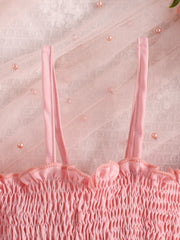 Pink smocked baby top with ruffled neckline and tulle overlay with pearls.