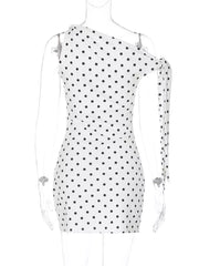 White polka dot mini dress with asymmetrical neckline and bow detail on sleeve.